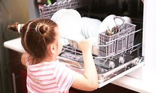 jente foran en oppvaskmaskin som er integrert  i kjøkkenbenk