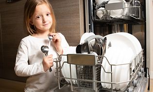 Et barn foran en integrert oppvaskmaskin 45 cm