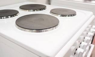 Nærbilde av elektrisk komfyr med kokeplate i støpejern