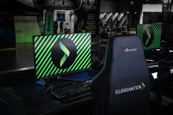 Skjerm og gaming-stol med Elkjøp-logo