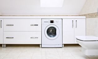 Integrert vaskemaskin i hvitt vaskerom