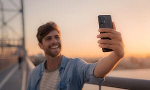 Mann tar et bilde med sin Motorola Edge 20-telefon
