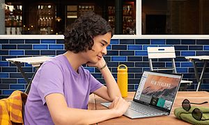 mann sitter på kafé med sin HP Pavilion 13