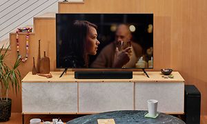Sonos Beam Gen 2 lydplanke og en TV som viser en kvinne