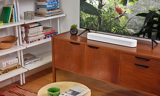 Sonos Beam Gen 2 lydplanke under en tv med naturprogram på skjermen