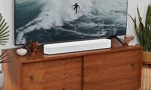 Sonos Beam Gen 2 lydplanke og en TV med en surfer på skjermen