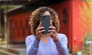 Kvinne som holder en Fairphone 4 foran ansiktet