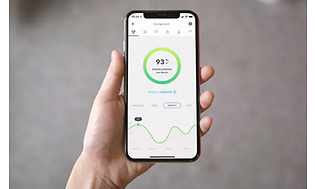 En smarttelefon i en hånd som viser radonnivåer i Airthings -appen