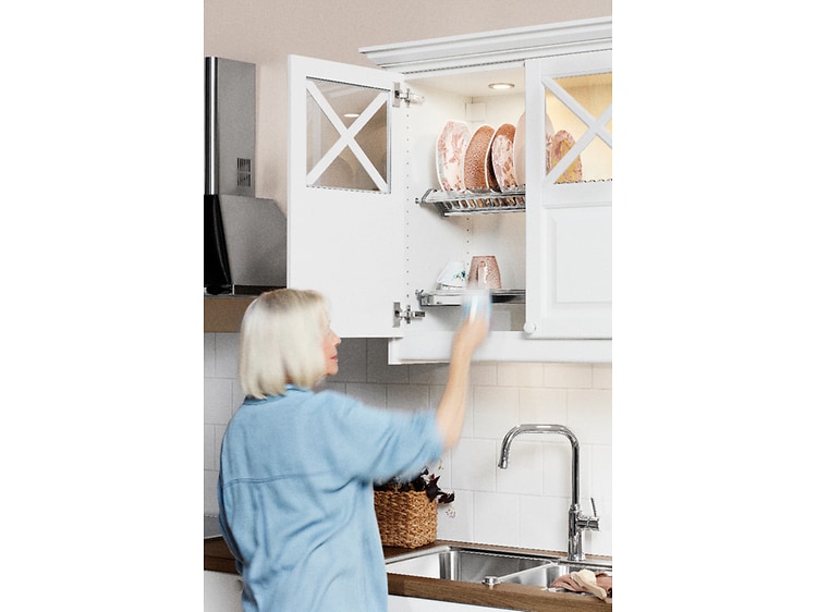 Kvinne som plasserer ren oppvask i vitrineskap på Epoq Heritage Classic White kjøkken