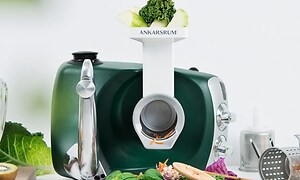 kjøkkenmaskin fra Ankarsrum brukt til å kutte ulike typer grønnsaker og med en brokkoli på toppen