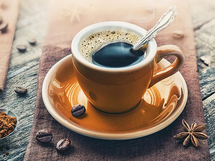  En kopp espresso med kaffebønner rundt