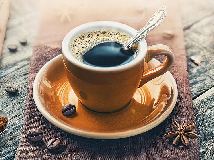 En kopp espresso med kaffebønner rundt