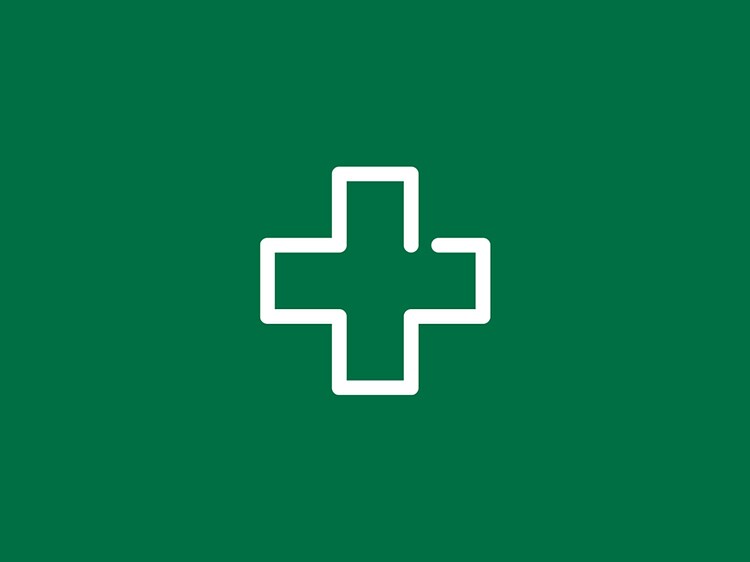 hvitt førstehjelpssymbol på en grønn bakgrunn