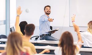 Airthings Wave Plus på vegg i klasserom bak lærer og elever