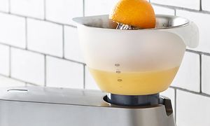 en kenwood maskin brukes til å presse appelsinjuice
