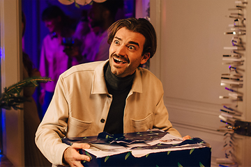 Man holding a Christmas gift looking excited