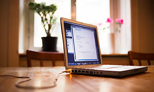 en laptop på et mord med ladekabel koblet i