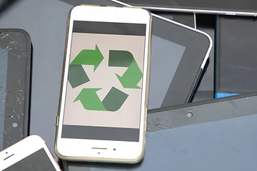 en hvit smarttetelefon med resirkuleringssymbol i grønt på skjermen