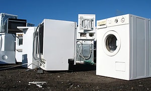 brukte vaskemaskiner og tørketromler samlet utendørs