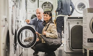 en kvinne i en elektronikkbutikk på jakt etter ny vaskemaskin