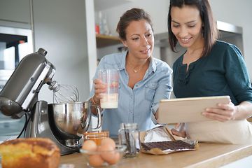 To kvinner som bruker en kjøkkenmaskin mens de baker