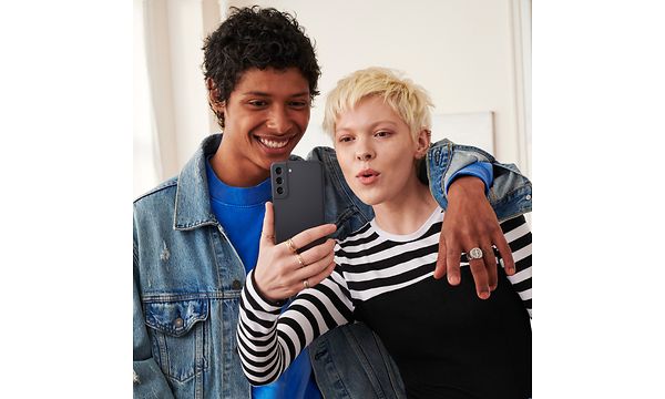  Kvinne og mann tar selfie med Samsung Galaxy S21 FE 