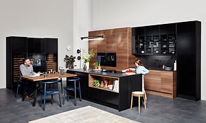EPOQ Edge Walnut og Black Ash kjøkken i en åpen kjøkkenløsning med spisebord og en kjøkkenøy