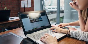 Two women using a laptop to browse the web