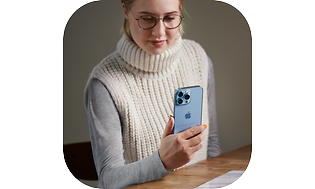 Kvinne holder iPhone 13