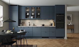 Blue grey EPOQ Trend kjøkken i en åpen kjøkkenløsning med integrert stekeovn, glasskap og spisebord