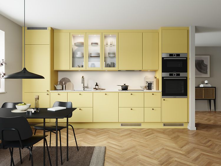 Mellow EPOQ Trend kjøkken i en åpen kjøkkenløsning med integrert stekeovn, glasskap og spisebord
