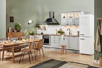 EPOQ Heritage White hvitt kjøkken i en åpen kjøkkenløsning med spisebord, kjøkkenvifte og kjøleskap