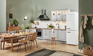 EPOQ Heritage White hvitt kjøkken i en åpen kjøkkenløsning med spisebord, kjøkkenvifte og kjøleskap