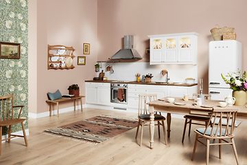 White EPOQ Heritage kjøkken i en åpen kjøkkenløsning med spisebord, kjøkkenvifte og kjøleskap