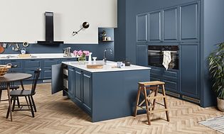 Blue EPOQ Heritage kjøkken i en åpen kjøkkenløsning med spisebord og kjøkkenøy