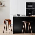 Hvitt EPOQ Integra kjøkken i åpen kjøkkenløsning, med barstoler og svart kjøkkenøy