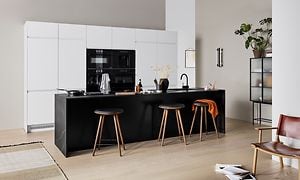 Epoq Integra hvitt kjøkken med en åpen kjøkkenløsning, og sort kjøkkenøy med barkrakker