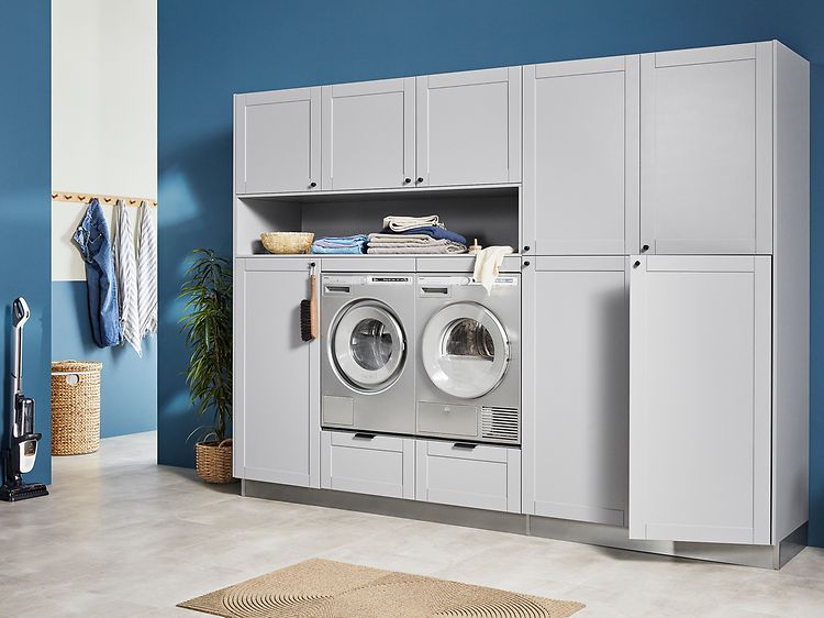 Light grey EPOQ Shaker vaskerom i en åpen løsning med vaskemaskin og tørketrommel