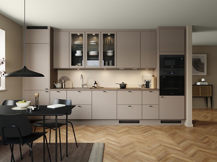 Epoq Trend Sand kjøkken i en åpen kjøkkenløsning med integrert stekeovn, vitrineskap og spisebord