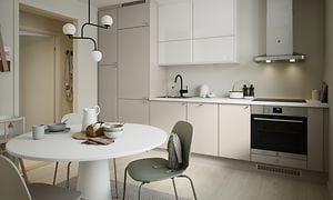 Epoq Trend Sand og Gloss White kjøkken i en åpen kjøkkenløsning med spisebord, veggmontert ventilator og integrert stekeovn