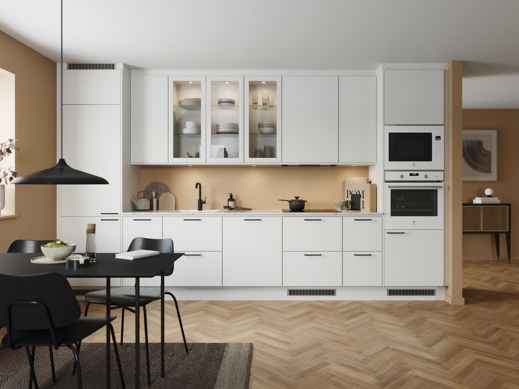 Classic white EPOQ Trend kjøkken i en åpen kjøkkenløsning med integrert stekeovn, glasskap og spisebord