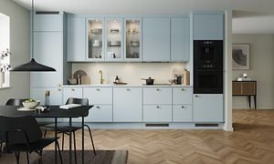 Blue mist EPOQ Trend i en åpen kjøkkenløsning med integrert stekeovn, glasskap og spisebord