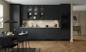 Black EPOQ Trend kjøkken i en åpen kjøkkenløsnng med integrert stekeovn, glasskap og spisebord