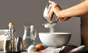 En person siler mel oppi en bakebolle