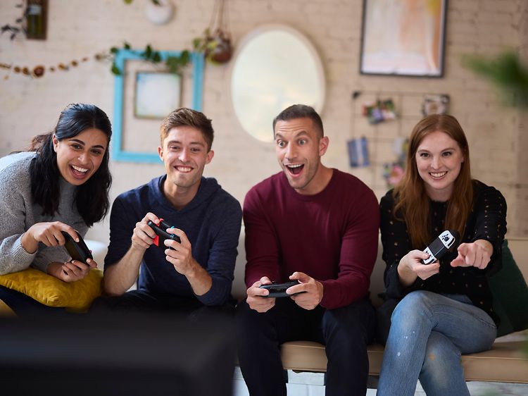 En gruppe venner som har det gøy og spiller Nintendo Switch sammen
