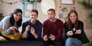 En gruppe venner som har det gøy og spiller Nintendo Switch sammen