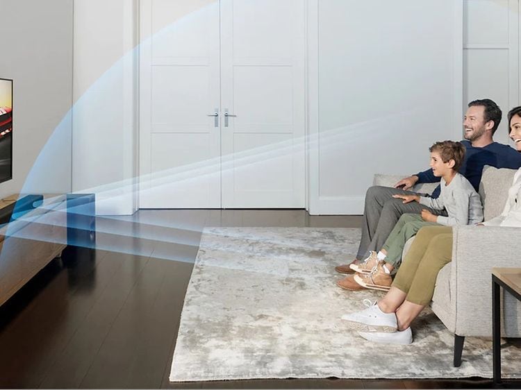En familie stiller i stua og ser på TV med lyd fra en Sony lydplanke