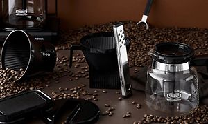 Moccamaster kaffetrakter, tilbehør og kaffebønner på bord