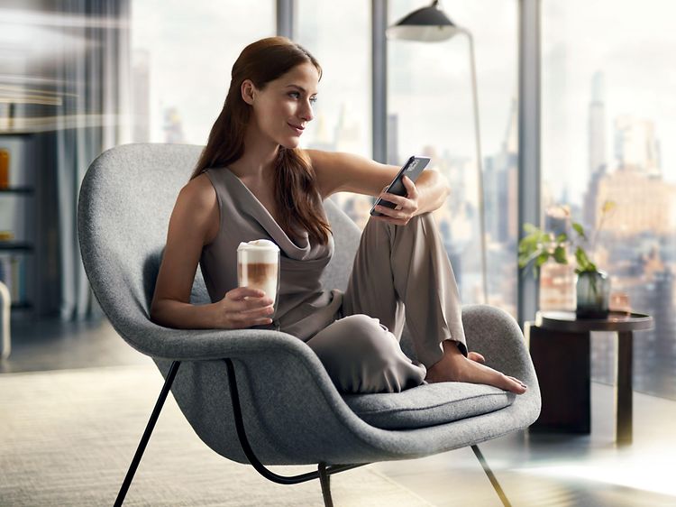 Kvinne som nyter en kopp kaffe fra Siemens espressomaskin