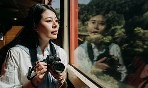 asiatisk kvinne med systemkamera på et tog